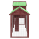 Holzhaustierhaus mit grünem geneigtem Dach und Drahtgitterseiten, mit einer zentralen Holzplattform im Inneren.