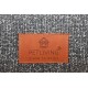 Braunes Lederetikett auf grauem, strukturiertem Haustierbett mit der Aufschrift 'PETLIVING ® place to enjoy' und Haus-Pfoten-Logo.
