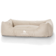 Beige Hundebett mit weichen, gepolsterten Seiten und einem zentralen Schlafbereich, mit dem Logo "KNUFFELWUFFF" deutlich sichtbar.