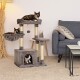 Ein gemütliches Wohnzimmer mit einem mehrstöckigen Katzenbaum und drei schildpattfarbenen Katzen: eine oben, eine in einem Korb und eine in einem Versteck.