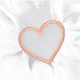 Close-up of a light gray fabric featuring a stitched peach-colored heart outline.