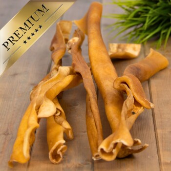 Hochwertige Hundekauartikel, die auf einer Holzoberfläche präsentiert werden, mit gedrehten, goldbraunen Streifen.