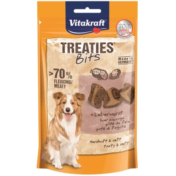 Eine Hundeleckerlipackung mit einem glücklichen Hund auf der Vorderseite, beschriftet mit "Vitakraft Treaties Bits" und den Texten ">70% Fleischig/Meaty" und "+Leberwurst".