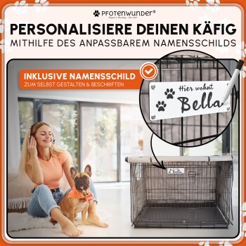 Mann in schwarzem Hoodie und Jeans kniet neben einem Deutschen Schäferhund vor einer Steinmauer auf Gras.