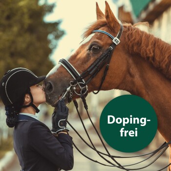 Ein Reiter in Reitkleidung interagiert sanft mit einem braunen Pferd, wobei ein grünes rundes Etikett mit der Aufschrift "Doping-frei" deutlich sichtbar ist.