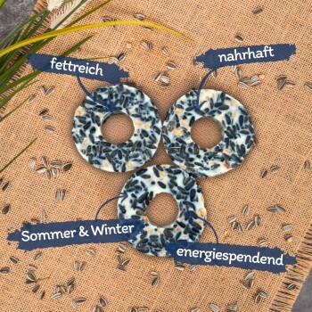 Drei Vogelfutterringe auf einem Jutesack-Hintergrund, beschriftet mit 'fettreich', 'nahrhaft', 'Sommer & Winter' und 'energiespendend.'
