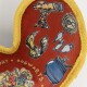 Red and yellow dog toy with Harry Potter-themed illustrations including a telescope, Golden Snitch, potion bottles, and cauldron.