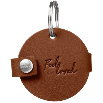 Runde braune Leder-Tiermarke mit Metall-Schlüsselring, mit der Prägung „Feel loved“ in Schreibschrift und silbernem Druckknopf.