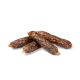 Quatre friandises pour chiens moelleuses et brunes en forme de saucisses, disposées sur un fond blanc.