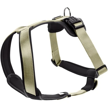 Ein strapazierfähiges, verstellbares Hundegeschirr in einem hellen Tan- und Schwarzfarbschema, mit gepolsterten Riemen und einem Metall-D-Ring zur Leinenbefestigung.