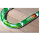 Eine grüne, gebogene Katzen-Spielbahn mit einem roten Licht, die auf einem Holzboden platziert ist und für interaktives Spielen konzipiert wurde.