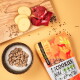 Ein glücklicher Hund sitzt in einem Wald neben einer bunten Verpackung von "FAVLY PET FOOD Cookies Wild", die hypoallergene, getreidefreie Zutaten hervorhebt.