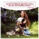 Eine Frau hält eine schwarze Katze neben einem grau-weißen Husky in einem Garten mit lila Blumen. Text: "Als Tierheilpraktikerin..." - Lena Huber.
