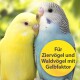 Zwei bunte Wellensittiche, gelb und blau, sind eng beieinander mit einem verschwommenen grünen Hintergrund. Text: "Für Ziervögel und Waldvögel mit Gelbfaktor."
