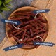 Ein Holzbrett mit dünnen rötlich-braunen Hundeleckerlis, beschriftet mit "Belohnung", "sensitiv", "fettarm" und "zahreinigend".