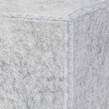 Gros plan d'un coin de lit pour animaux en feutre gris, mettant en valeur sa texture douce et ses coutures soignées.