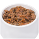 Eine weiße Schüssel gefüllt mit feuchtem, stückigem Haustierfutter mit Hackfleisch und sichtbaren Stücken von orangefarbenem Gemüse.
