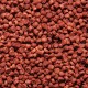 Nahaufnahme von kleinen, runden, rötlich-braunen Haustierfutterpellets, die über eine Oberfläche verstreut sind.