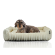 Ein gemütliches, plüschiges Hundebett mit einem wellenförmigen Design, auf dem ein entspannter Dackel bequem liegt.