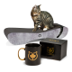 Eine getigerte Katze sitzt auf einer gebogenen Sitzfläche neben einer schwarzen Tasse mit einem goldenen Katzenlogo und einer Box mit der Aufschrift "CanadianCat."