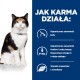 Kot siedzi obok niebieskiego panelu wyjaśniającego korzyści z jego jedzenia: niska zawartość jodu, fosforu, sodu, omega-3 i wysoka L-karnityna.