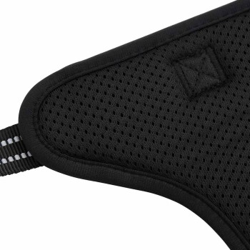 Nahaufnahme eines schwarzen Haustiergeschirrs mit einer strapazierfähigen Schnalle und reflektierenden Nähten, das den sicheren Verschlussmechanismus zeigt.