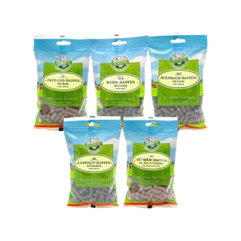 Fünf bunte Snacks für Haustiere in Tüten, die mit verschiedenen Fleischsorten beschriftet sind: Huhn, Lamm, Lachs, Truthahn und Rind & Truthahn.