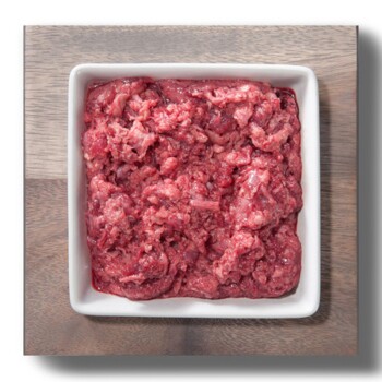 Rohe Stücke rotes Fleisch, die auf einem weißen Hintergrund präsentiert werden und Marmorierung und Textur zeigen.