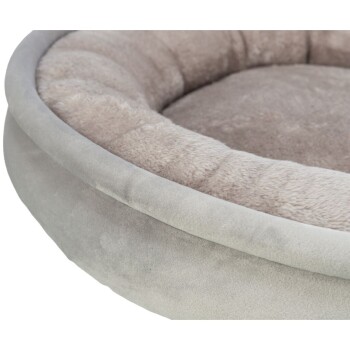 Eine Nahaufnahme eines weichen, runden Haustierbettes mit einem plüschigen, hellgrauen Innenraum und einem glatten, grauen Außenraum.
