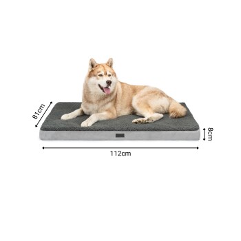 Ein entspannter Siberian Husky, der auf einem plüschigen grauen Hundebett liegt, das 112 cm x 81 cm x 8 cm misst.