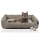 Eine flauschige getigerte Katze, die in einem gemütlichen, beigen Haustierbett mit strukturiertem Rand liegt, begleitet von zwei kleinen Wollknäueln.