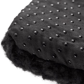 Nahaufnahme eines schwarzen Haustierbettes mit einer strukturierten, gepunkteten Oberfläche und einer flauschigen, weichen Unterseite.
