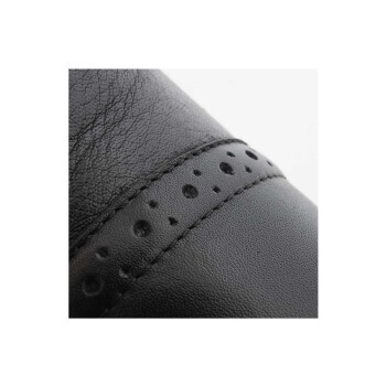 Nahaufnahme eines schwarzen Lederschuhs mit einer strukturierten Oberfläche und einem dekorativen Band mit kleinen Perforationen.