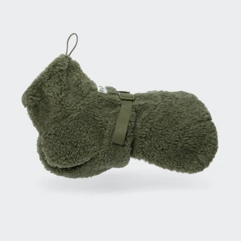 Olivgrünes Sherpa-Hundespielzeug in Form eines Fäustlings mit Schlaufe, Riemen und kleinem weißen Etikett mit schwarzem Text.