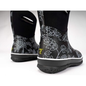 Schwarze, blumenmusterte Haustierstiefel mit einer weißen Sohle und einem gelben Logo, die ein stilvolles und funktionales Design zeigen.