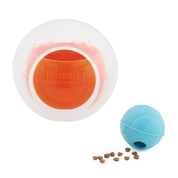 Interaktives Haustierspielzeugset mit einem klaren Ball mit einem orangefarbenen inneren Ball und einem blauen Ball, mit verstreuten Haustierleckereien in der Nähe.
