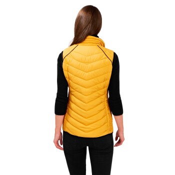 Eine Frau mit langen braunen Haaren ist von hinten zu sehen, trägt eine leuchtend gelbe Steppweste über einem schwarzen Langarmshirt und schwarzen Hosen.