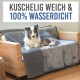 Ein flauschiger Hund ruht auf einer gemütlichen, wasserdichten grauen Tierdecke, die über eine Rattansofa gelegt ist, mit dem Text "KUSCHELIG WEICH & 100% WASSERDICHT" darüber.