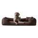 Ein grauer Weimaraner-Hund liegt auf einem plüschigen braunen Hundebett mit erhöhten Seiten, das ein kleines Logotag auf der Vorderseite hat.