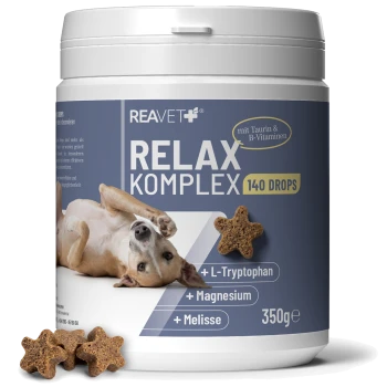 Weißes Glas mit der Aufschrift 'REAVET RELAX KOMPLEX 140 DROPS 350g' mit braunen sternförmigen Leckerlis und +L‑Tryptophan +Magnesium +Melisse