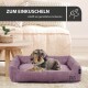Ein gemütliches lila Hundebett mit einem Dackel, der darauf ruht, mit dem Text "ZUM EINKUSCHELN" und "schafft ein gemütliches Ambiente."