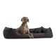 Ein grauer Weimaraner sitzt bequem auf einem plüschigen schwarzen Hundebett und schaut aufmerksam zur Seite in einem hellen, modernen Raum.