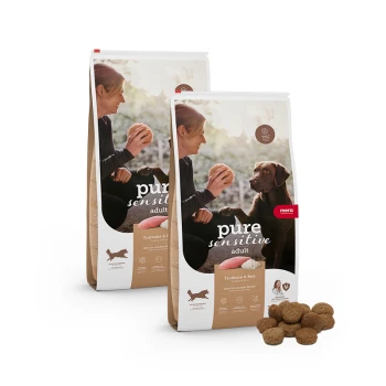 Zwei Säcke 'pure sensitive adult' Hundefutter von Mera, mit Truthahn und Reis, mit vor ihnen angezeigten Krokettenstücken.