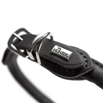 Nahaufnahme eines schwarzen Lederhalsbands für Hunde mit einer silbernen Schnalle und einem Metallschild mit dem Markennamen 'HUNTER.'