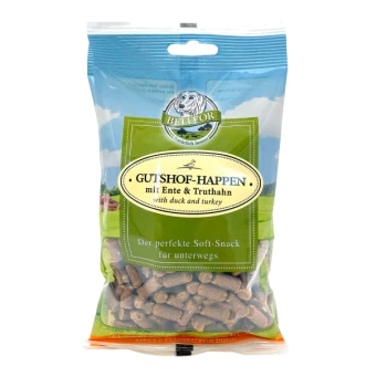 Eine Tüte BELLEFOR-Hundeleckerlis, beschriftet mit "GUTSHOF-HAPPEN mit Ente & Truthahn" (mit Ente und Truthahn), mit sichtbaren weichen Snackstücken im Inneren.