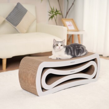 Eine grau-weiße Katze, die auf einem modernen, geschwungenen Kratzbaum mit brauner Oberfläche entspannt, in einem gemütlichen Wohnzimmer mit einem weißen Teppich.