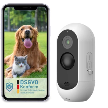 Ein Smartphone, das einen glücklichen Golden Retriever und eine Katze vor einem grasbewachsenen Hintergrund zeigt, neben einer weißen Haustierkamera mit einem Reset-Knopf.