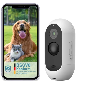 Ein Smartphone, das einen glücklichen Golden Retriever und eine Katze vor einem grasbewachsenen Hintergrund zeigt, neben einer weißen Haustierkamera mit einem Reset-Knopf.
