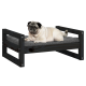 Ein Mops liegt auf einem stilvollen schwarzen Holzhaustierbett mit einem grauen Kissen, das Komfort und modernes Design zeigt.
