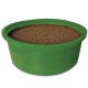 Grüne Kunststoff-Haustierfutterschale, gefüllt mit braunem Futter, seitlich betrachtet.